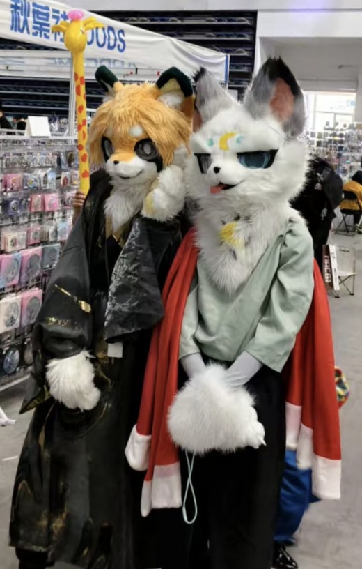 漫展展位前的两位 Furry 装扮参与者合照